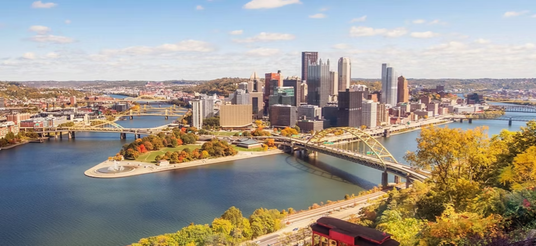 An aerial view of Downtown Pittsburgh, where iconic skyscrapers and the three rivers converge, where the steel industry was born.